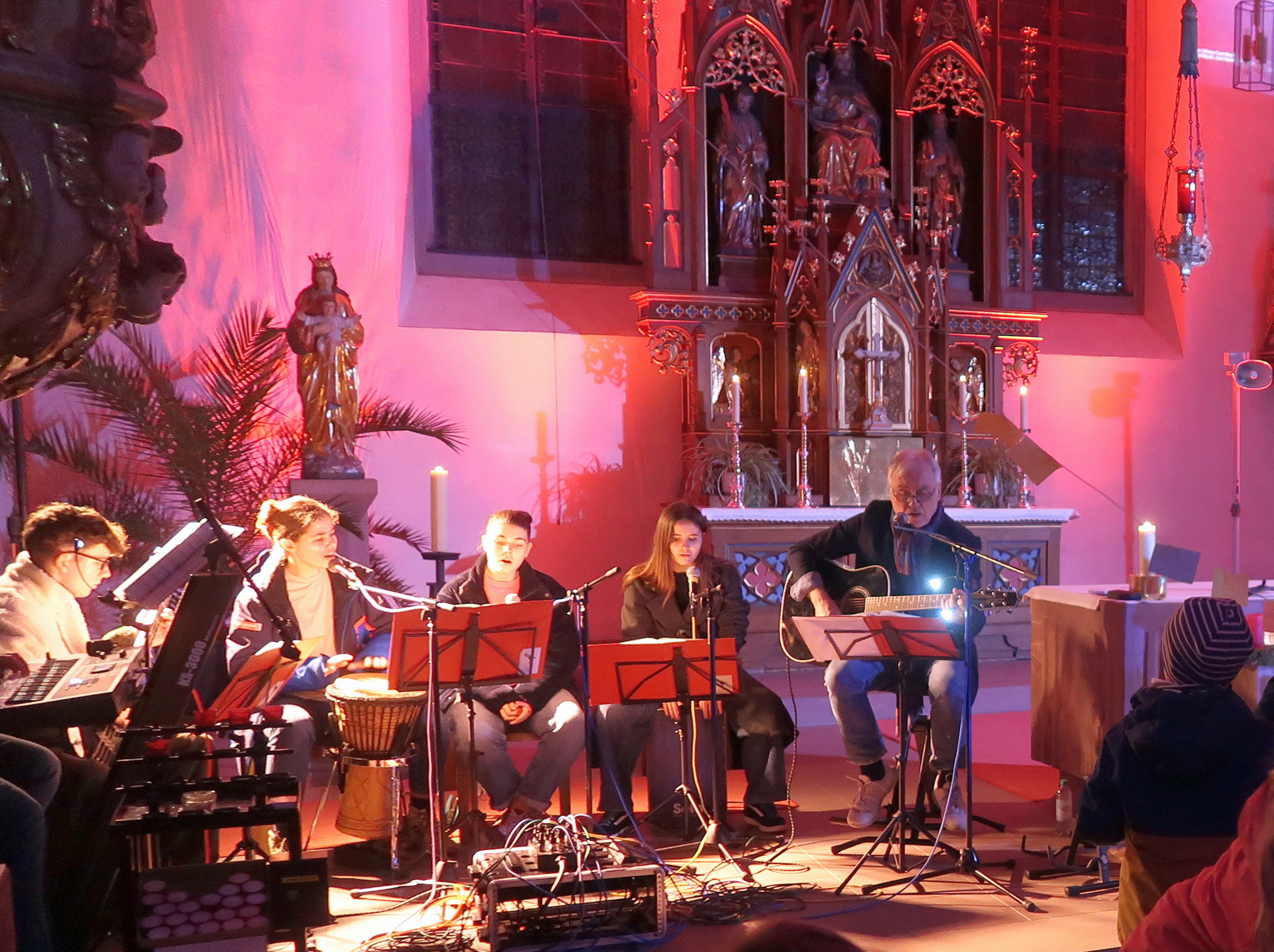 Ein Blick auf die Band. Die Burggrumbacher Kirche ist farbig beleuchtet.