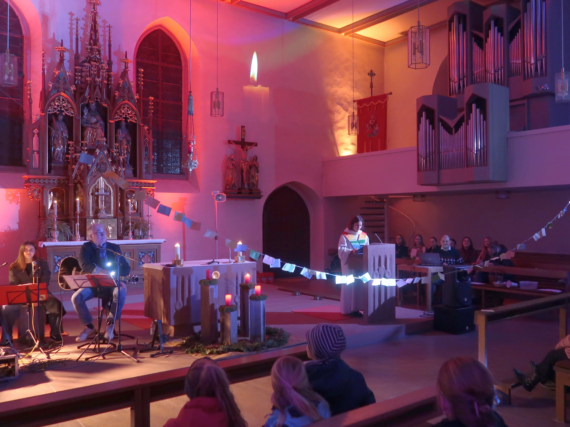 Am Ambo steht die Lektorin. Über ihr ist eine Schnur mit Zetteln daran.