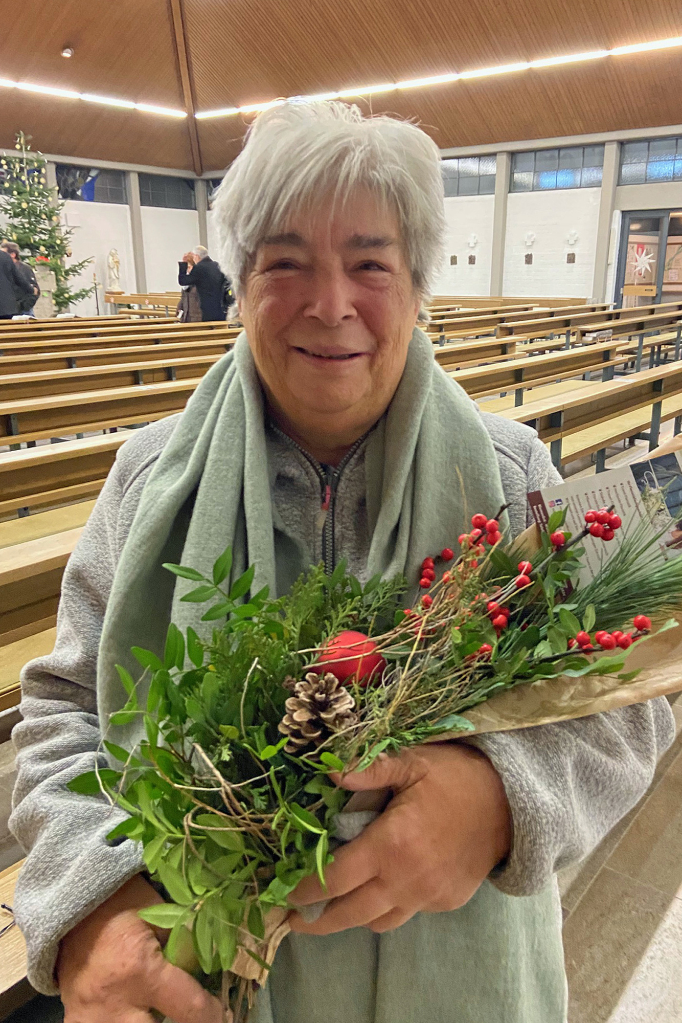 Lisbeth Rügemer blickt in die Kamera und hat einen Blumenstrauß in ihren Händen.