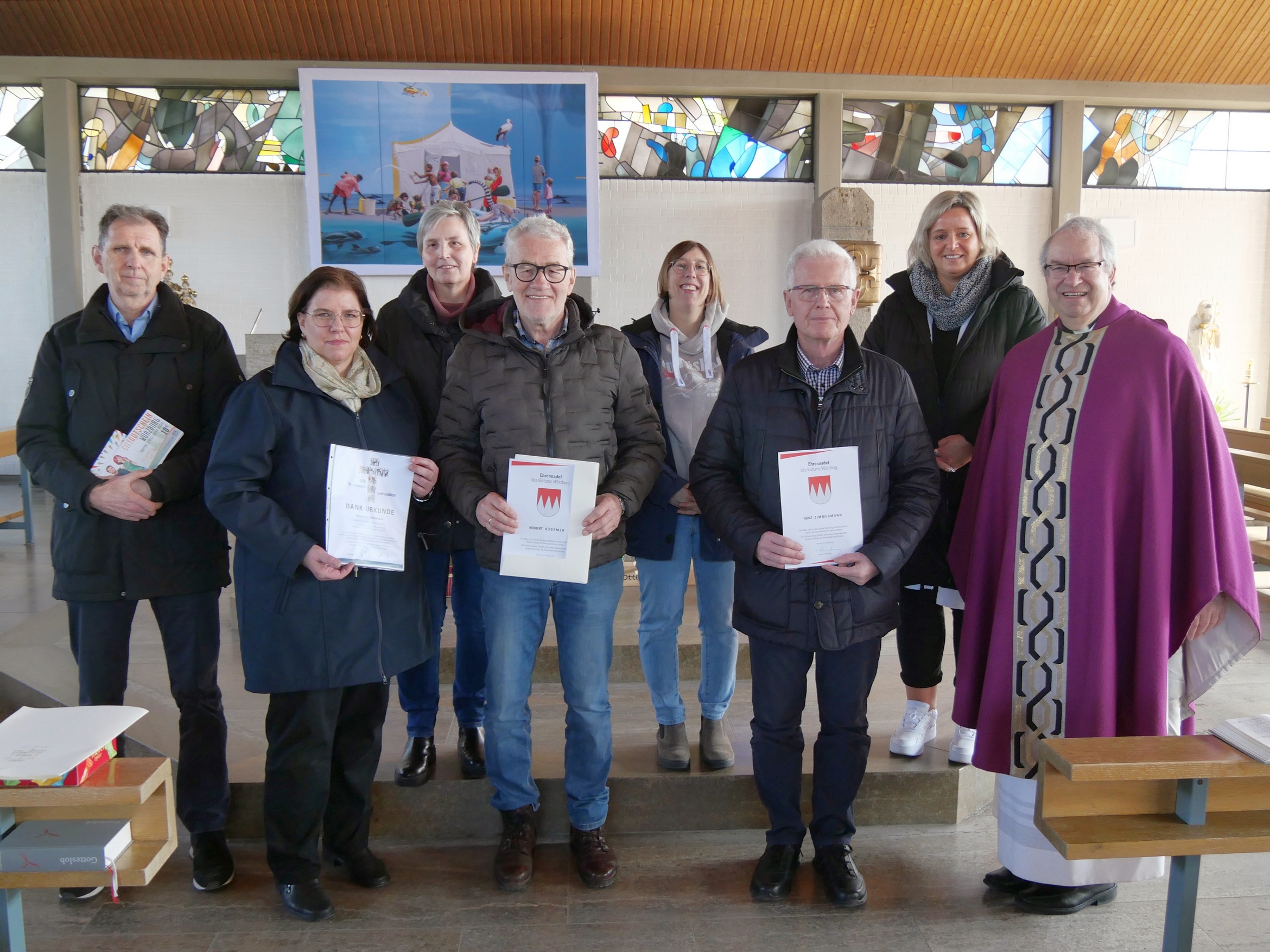 Bei diesem Gruppenbild in der Kirche St. Alban in Erbshausen-Sulzwiesen schauen alle Personen in die Kamera.