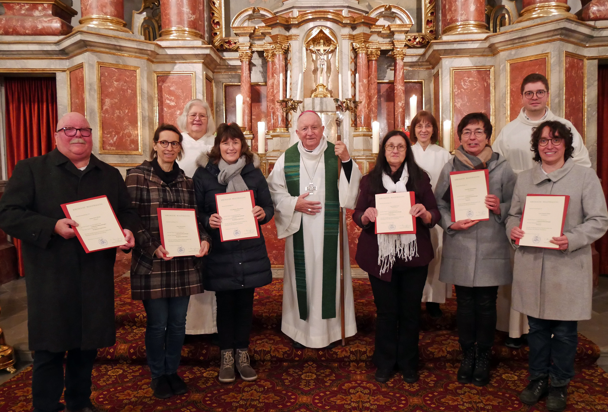 Gruppenbild mit den Urkunden, dem Weihbischof und den Begleitern