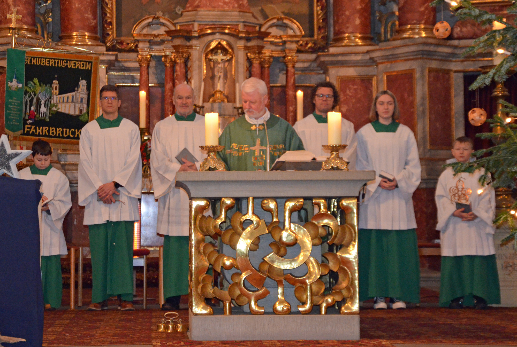 Eine Gruppe mit sechs Personen steht hinter dem Altar.