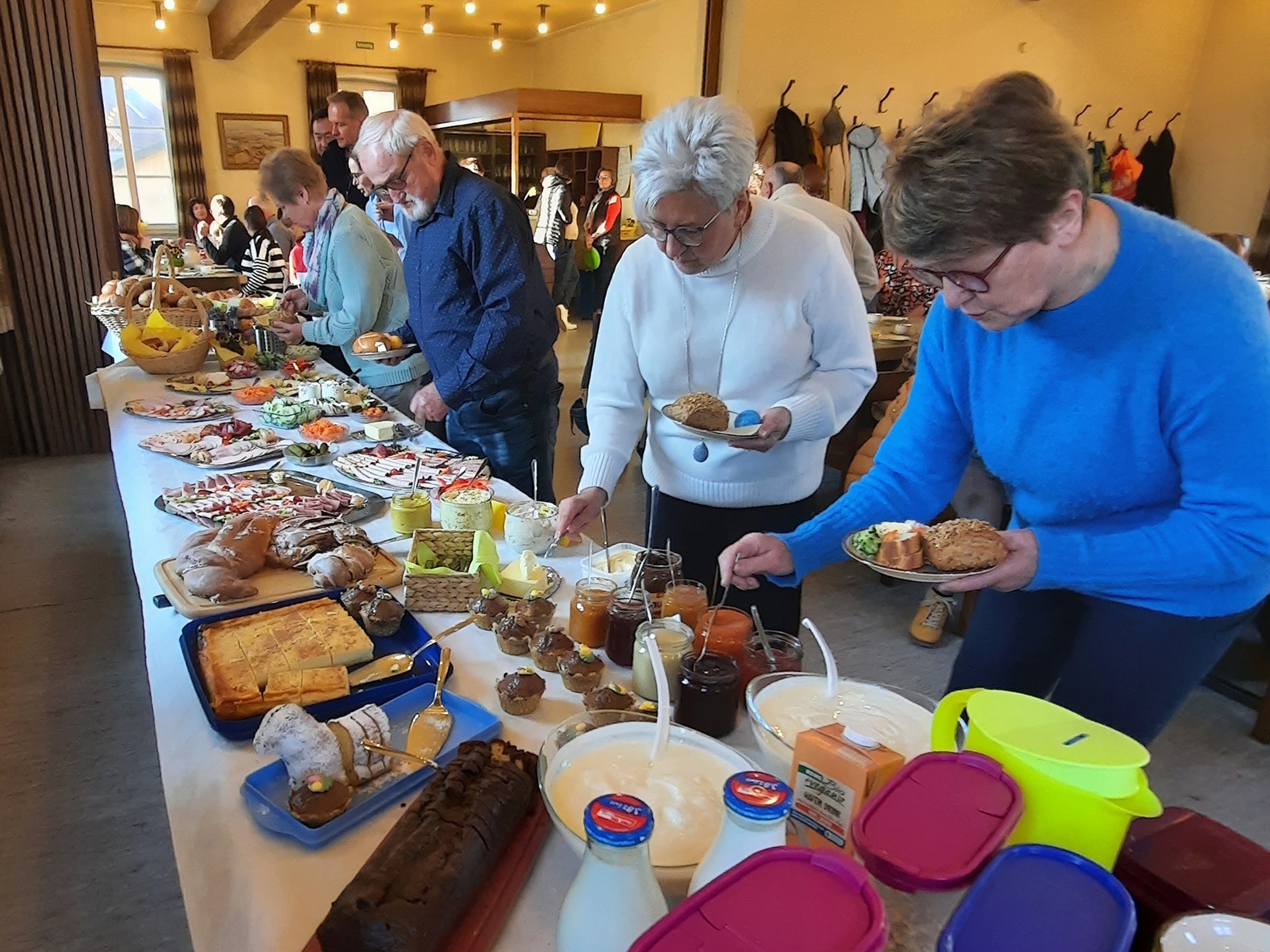 Auf einem langen Tisch steht ein großes Angebot an Frühstücksessen.