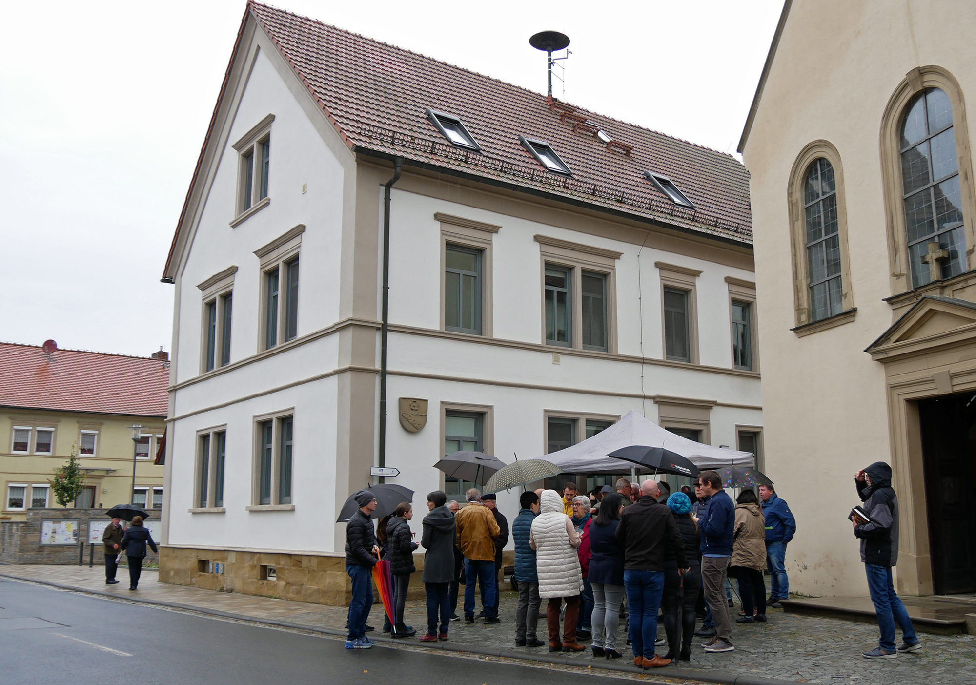 Eine Gruppe steht beim Sektempfang vor der Kirche St. Wolfgang