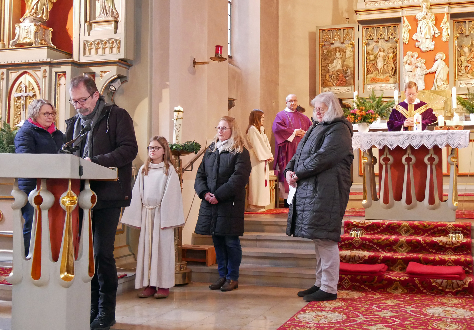 Mehrere Personen stehen am Ambo in der Opferbaumer Kirche