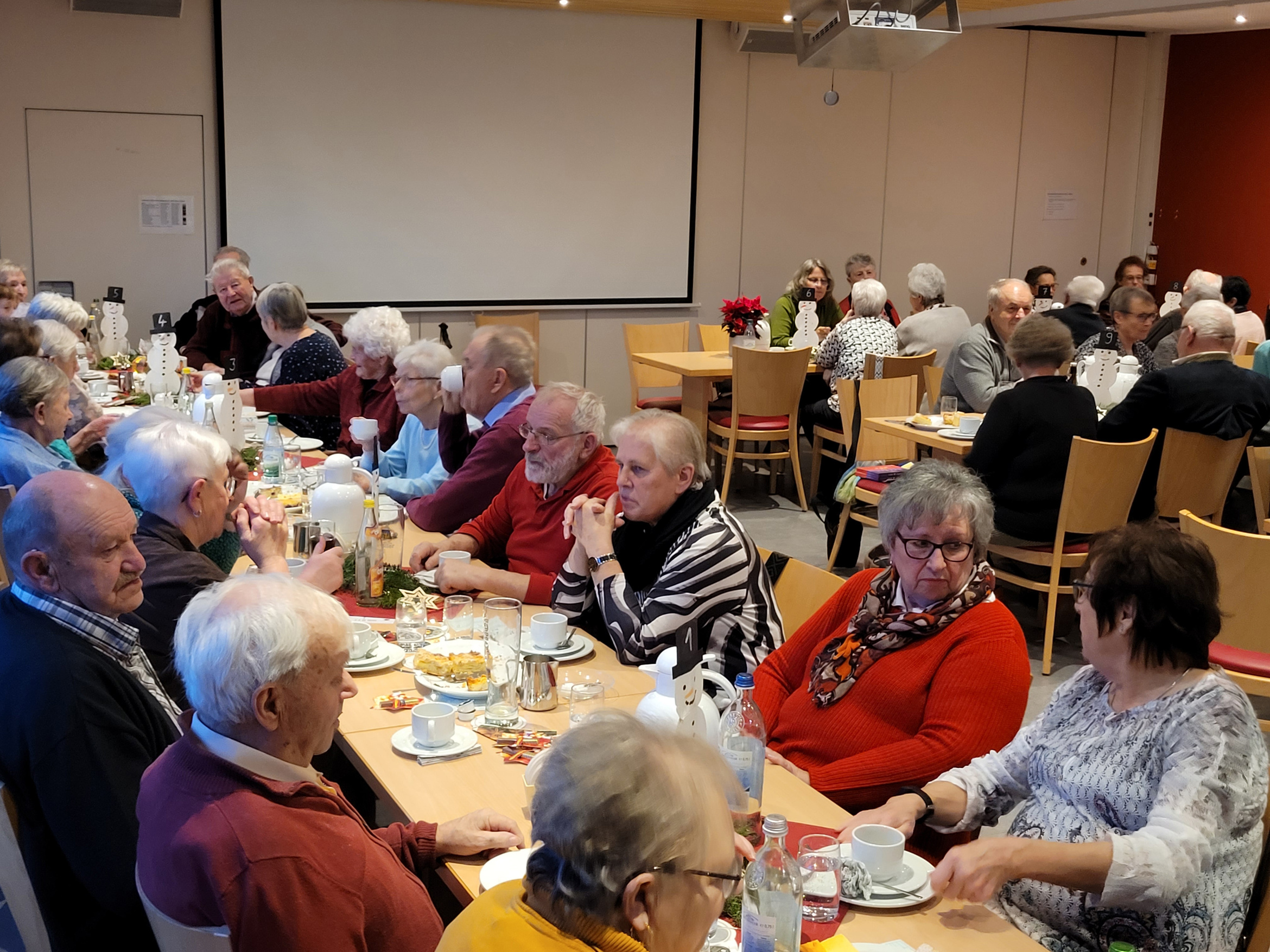 Im Sportheim wird an den Tischen Kaffee getrunken.