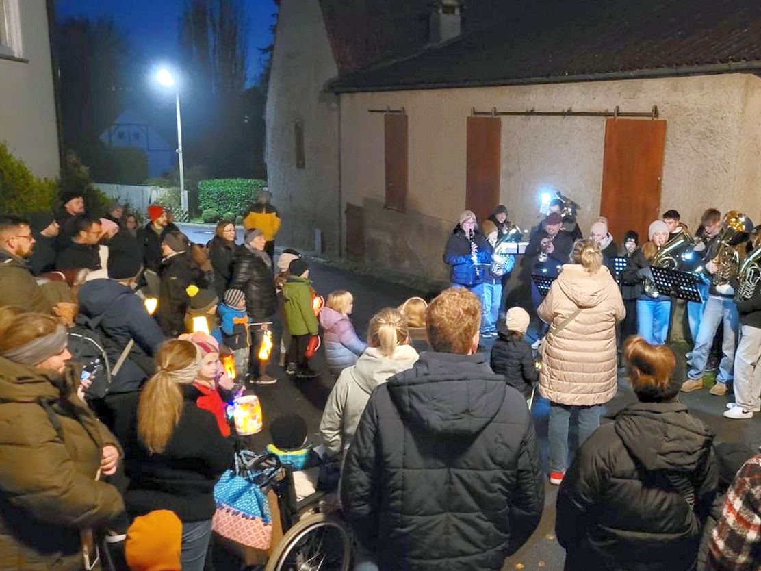 In einem Rund stehen viele Menschen. Es ist dunkel.