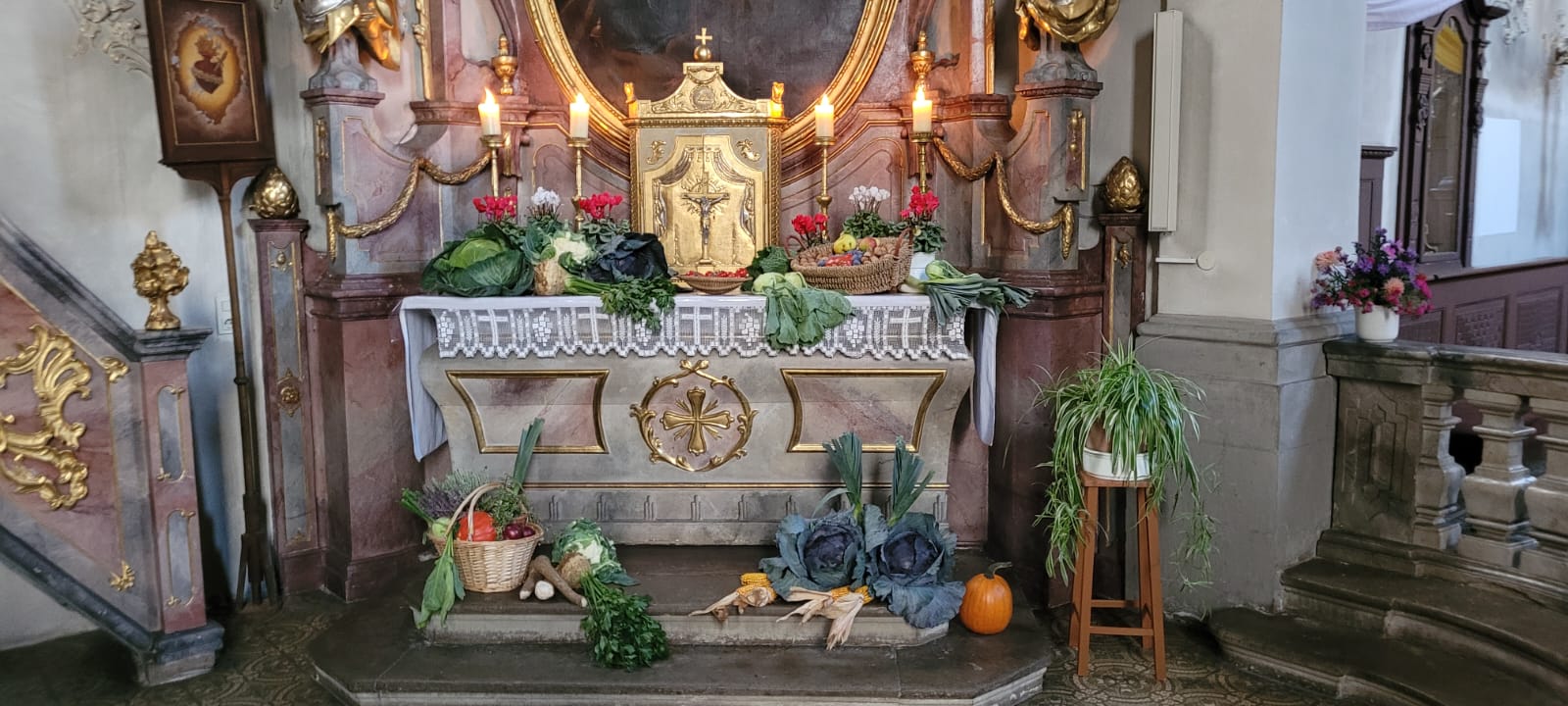 Der Seitenaltar in einer barocken Kirche ist mit Feldfrüchten dekoriert.