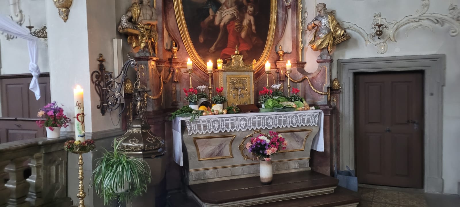 Der Seitenaltar einer barocken Kirche ist mit Feldfrüchten dekoriert.