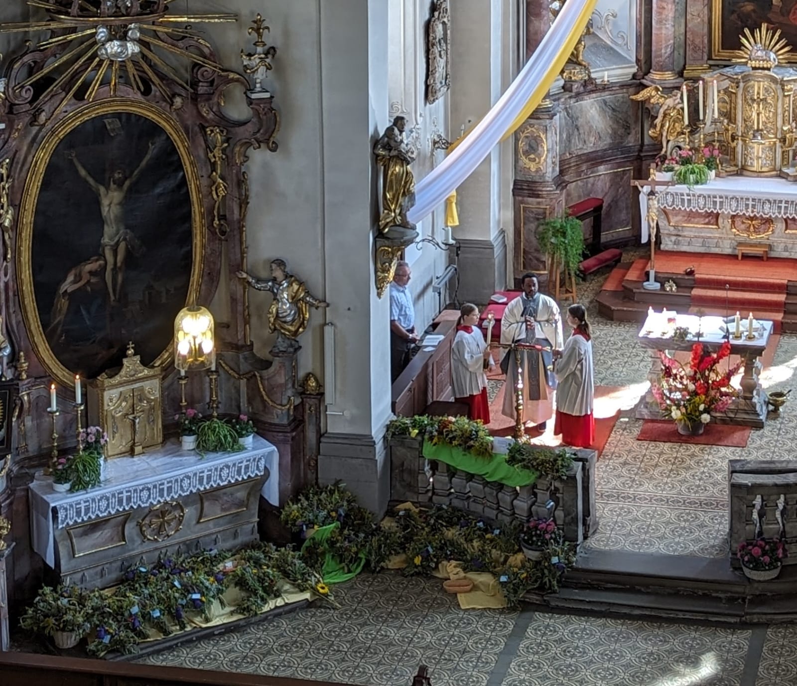Blick in den Altarraum, wo ein Priester am Ambo steht.