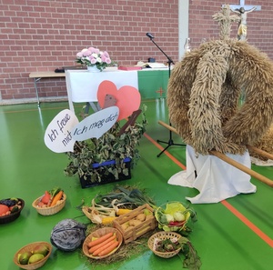 Das Foto zeigt einen Erntealtar mit verschiedenen Früchten und einer Erntekrone. Auf Schildern steht: "Ich freue mich" und "ich mag dich"