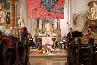 Im Gang in einer Kirche mit dem Blick auf dem Altarraum. In den Bänken sind mehrere Frauen.
