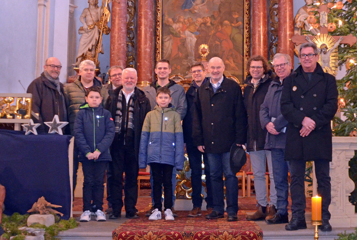 Eine Gruppe mit Erwachsenen und Kindern schaut in die Kamera.