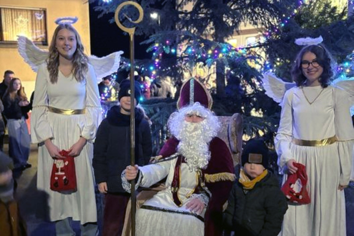 Ein Nikolaus sitzt in der Mitte. Um ihn herum sind Kinder.