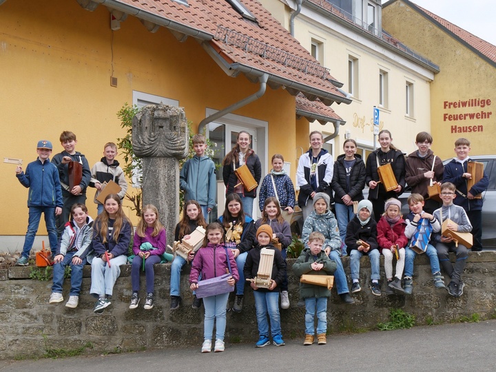 Ein Gruppenbild vor einer Mauer in der Dorfmitte von Hausen.