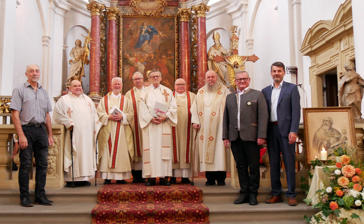 Neun Männer stehen im Altarraum