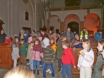 Foto in der Kirche. Die Kinder und Erwachsenen halten sich an den Händen.