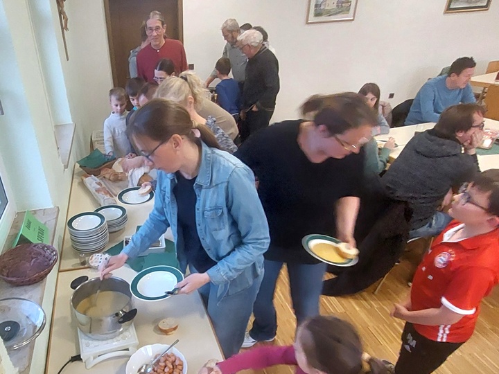 Eine Gruppe mit Erwachsenen und Kindern beim Essen holen.