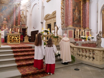 Blick vom Kirchenschiff nach vorn in den Chorraum. Auf dem Foto sind Pater Matthäus und zwei Ministrantinen von hinten zu sehen.
