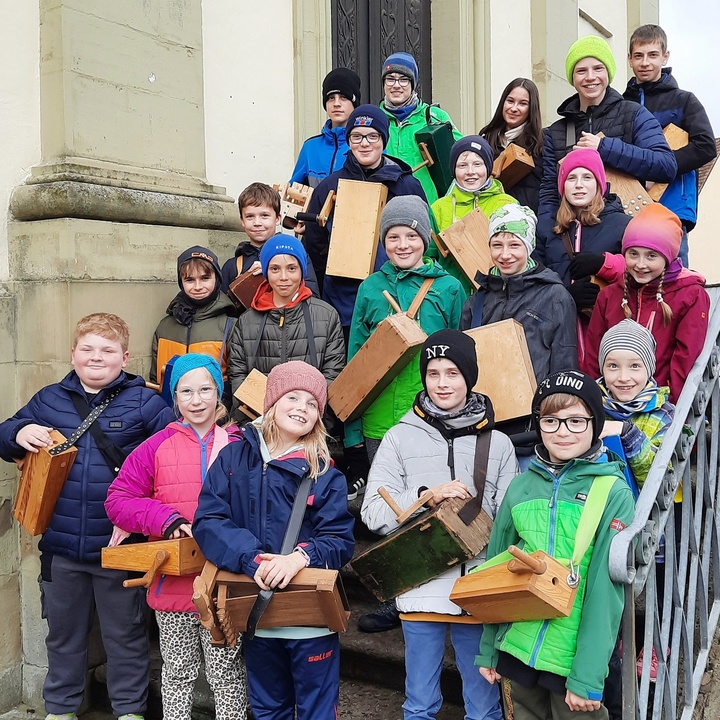 Auf der Kirchentreppe stehen viele Kinder mit ihren Rappelkästen.