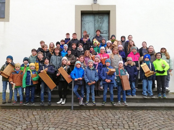 Ein Gruppenbild mit vielen Kindern und Jugendlichen auf den Kirchentreppen.