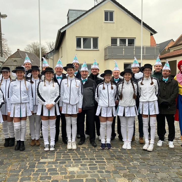 Ein Gruppenbild auf dem Kirchplatz in Burggrumbach. Alle haben Faschingskostüme an.