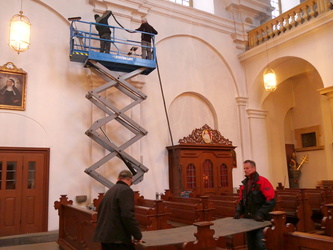 Arbeiten auf der Hebebühne zwischen zwei Beichtstühlen.