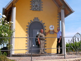 Die Kapelle in den Weinbergen aus der Ferne mit den zwei Männern davor.