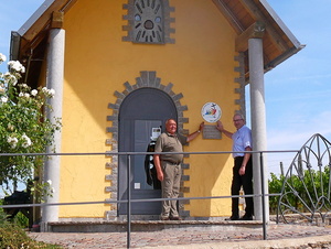 Die Kapelle in den Weinbergen aus der Ferne mit den zwei Männern davor.