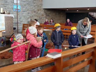 Im Altarraum der Kiche in Dipbach sind ein paar Kinder. Sie haben Gegenstände in den Händen, beispielsweise eine Zollstock.