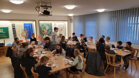 Blick in einem Raum. An zwei Tischen sitzen Kinder beim Frühstück.
