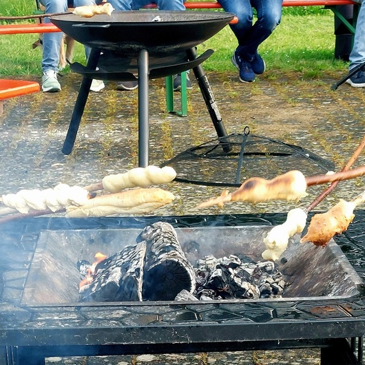 Zwei Feuerstellen mit Grillgut darüber