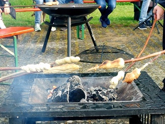 Zwei Feuerstellen mit Grillgut darüber