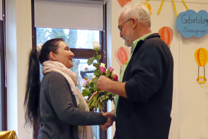 Ein Mann gratuliert der Jubilarin mit Blumen 