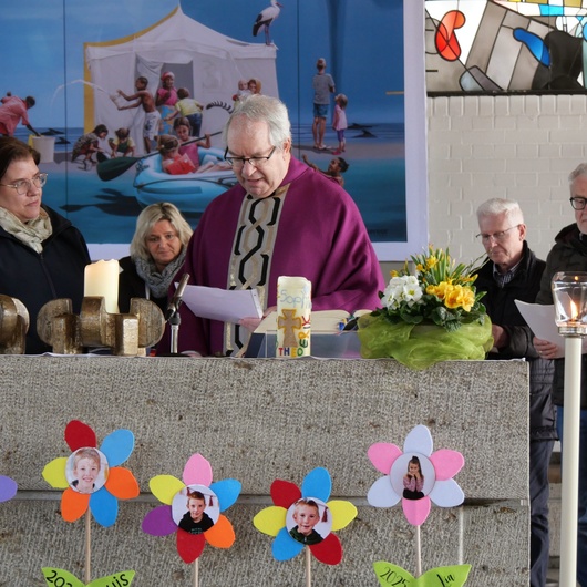 Der Pfarrer liest am Altar eine Urkunde vor.