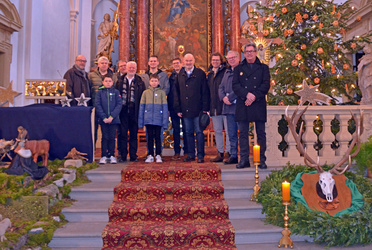 Eine Gruppe mit Erwachsenen und Kindern steht auf den Altarstufen.