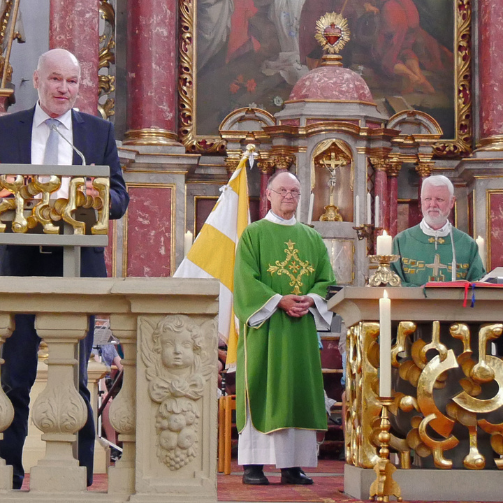 Drei Männer stehen im Altarraum der Kirche Fährbrück. einer hält eine Ansprache.