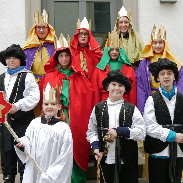 Die zehn Sternsinger stehen für ein Gruppenfoto auf einer Treppe