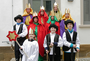 Die zehn Sternsinger stehen für ein Gruppenfoto auf einer Treppe