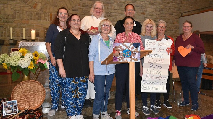 Gruppenbild im Altarraum mit einem Plakat auf dem steht: Sende deinen Geist der ... Weisheit, Einsicht, Rates, Stärke, Erkenntnis, Frömmigkeit, Gottesfurcht