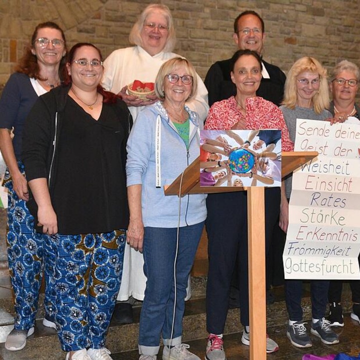 Gruppenbild im Altarraum mit einem Plakat auf dem steht: Sende deinen Geist der ... Weisheit, Einsicht, Rates, Stärke, Erkenntnis, Frömmigkeit, Gottesfurcht