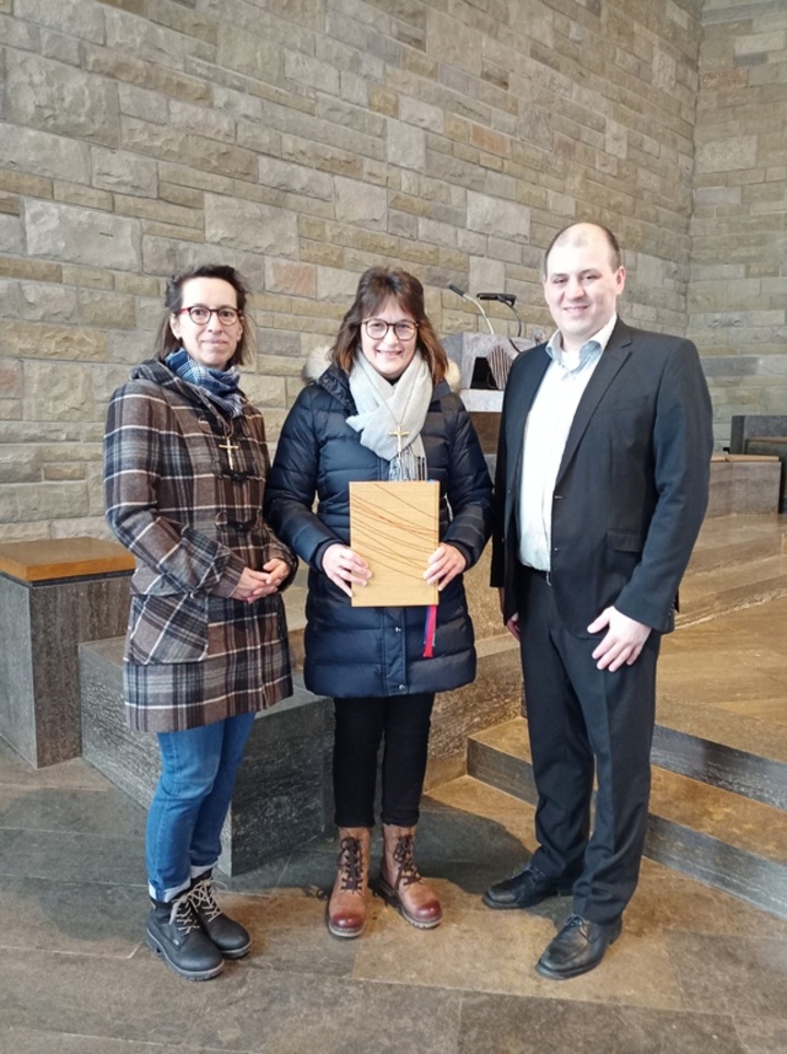 Gruppenbild mit drei Personen, die in die Kamera blicken.