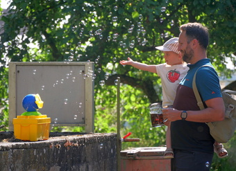 Ein Vater und sein Kind freuen sich über die Seifenblasen.