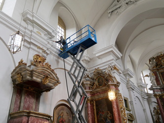 Blick von unten zu den Arbeiten auf der Hebebühne in der Höhe.