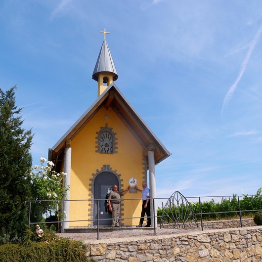 Die Kapelle im Grünen unter blauem Himmel.