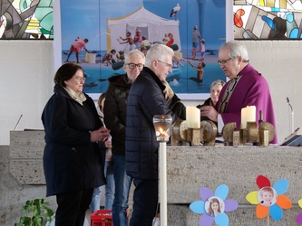 Männer und Frauen stehen um den Altar der Kirche.