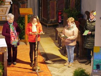 Vier Frauen stehen im Altarraum. Sie lesen etwas vor.