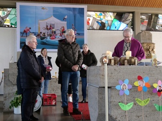 Um den Altar der Kirche in Erbshausen stehen Frauen und Männer.