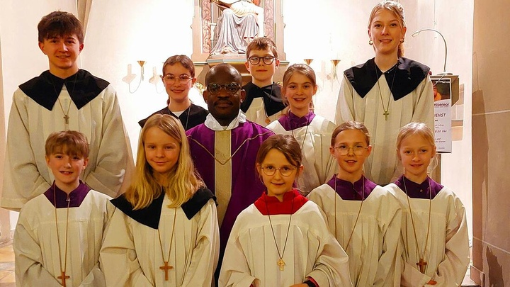 Gruppenbild mehrerer Ministranen mit dem Pfarrer in der Mitte.
