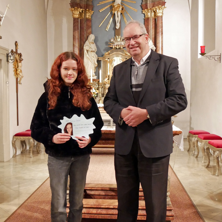 Firmling Evelyn und Pfarrer Helmut Rügamer stehen vor dem Altar in der Kirche in Hausen.